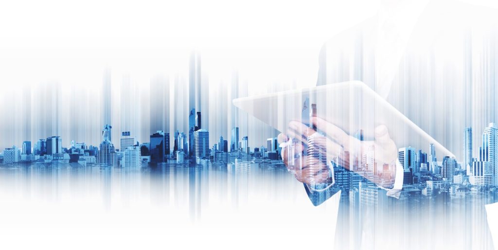 Double exposure image of a businessman holding a tablet overlaid with a modern city skyline, representing business technology and urban development